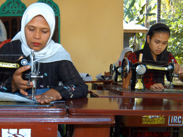 Asnidar (till vänster) och Yusnandi är skräddare i byn Pante Gura, i västra Indonesien. De sitter vid sina symaskiner.