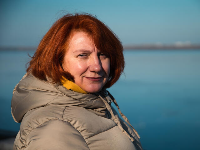 Oleksandra standing against a shoreline