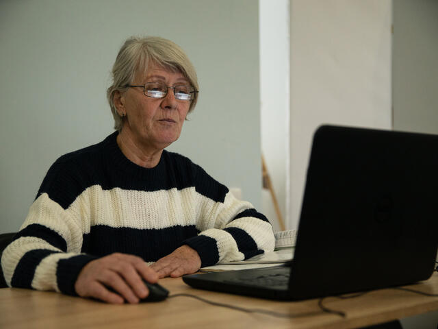 Iryna using a computer in the Dnipro women's safe space