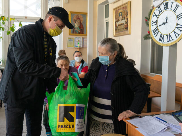 Alla receives a bag of supplies from an IRC worker