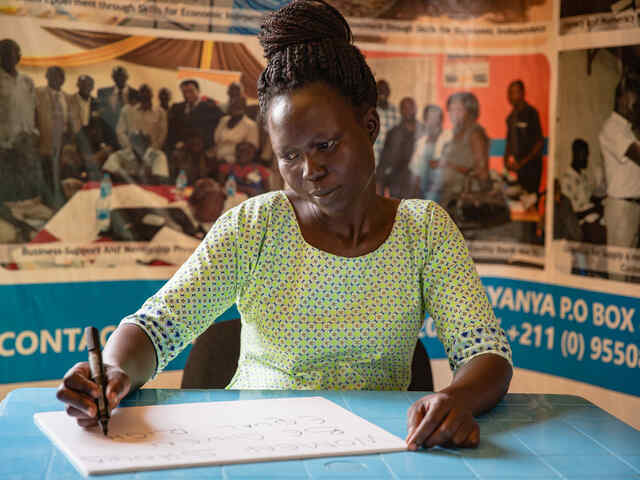 RESCUE:s lösning: en kvinna som jobbar för en kvinnorättsorganisation gör pappersarbete vid ett skrivbord.