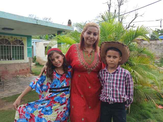 RESCUE:s lösning: En mamma från Venezuela poserar för ett foto med sina två barn. Barnen har fått hjälp av RESCUE:s program "Play Well".