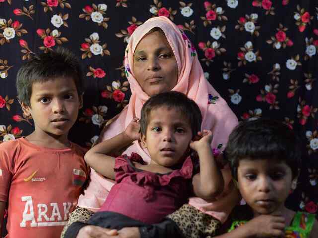 Drabbade av en översvämning - en mamma och hennes 3 barn håller om varandra, de är sårbara för översvämningar i Bangladesh. 