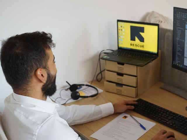 Ozair sitting at his work desk in the IRC's office in Milan, Italy