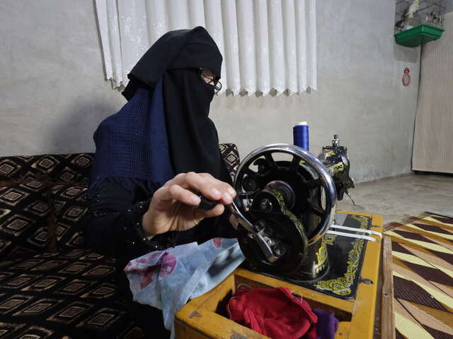Fatima uses her sewing machine. 