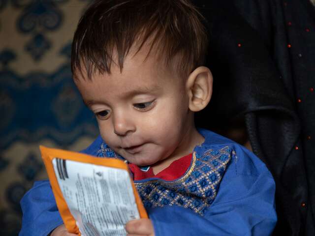 Shams Ullah holds a packet of RUTF (a micronutrient, energy concentrated food) for malnutrition treatment at the IRC mobile health clinic.