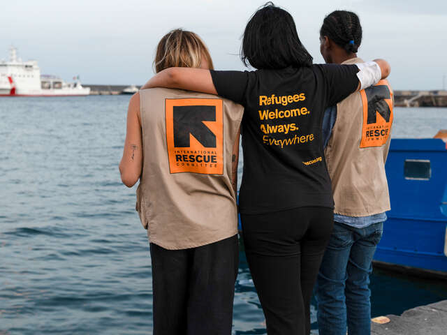 Tre personer i RESCUE-västar vid en hamn i Italien. RESCUE ger skydd och stödd till människor som överlevt resan över Medelhavet.