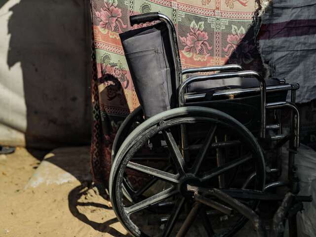 A wheelchair sitting outside a temporary shelter at one of IRC’s global program sites. 