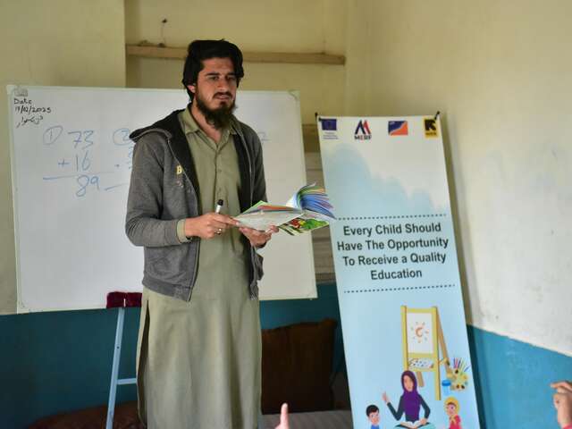 Teacher standing in front of a white board 