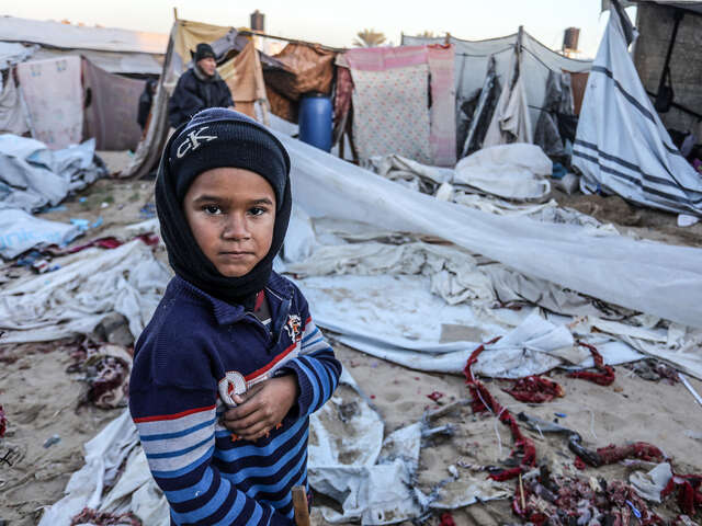 En pojke i Gaza står vid förstörda tält mitt i vintern. RESCUE finns på plats med stöd.