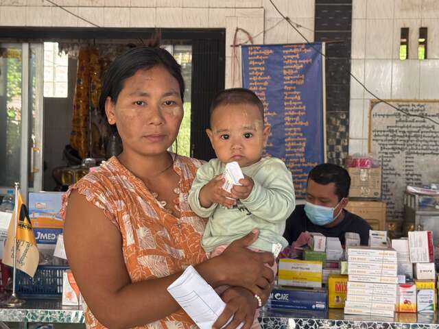 En mamma håller i sin bebis under ett besök på RESCUE:s mobila hälsoklinik.