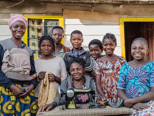 Gentille poses with her foster family outside their home in Numbi.
