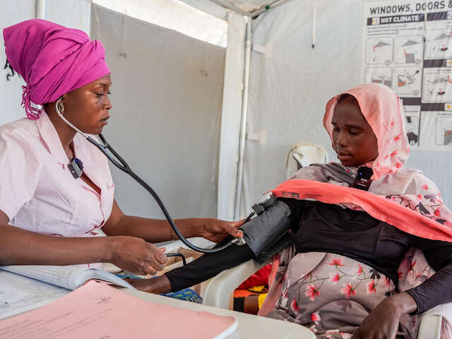 A midwife tends to her pregnant patient, 38-year-old Bousseina, at the IRC run mobile health clinic in Iridimi camp. 