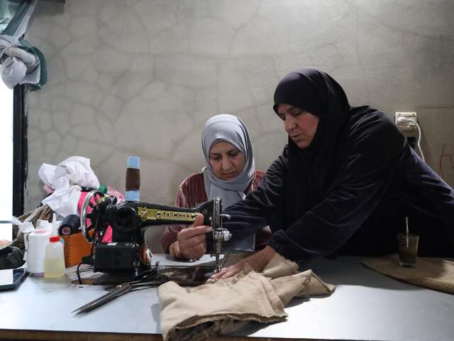 Al-Qusayr, Homs province, Syria. Bayan, 32, is seen sewing at home under her mother’s tutelage. “My mother used to work as a seamstress, but she can’t anymore so she taught me.… I’m the only breadwinner in the family now, supporting around ten people through sewing,” Bayan explained.​