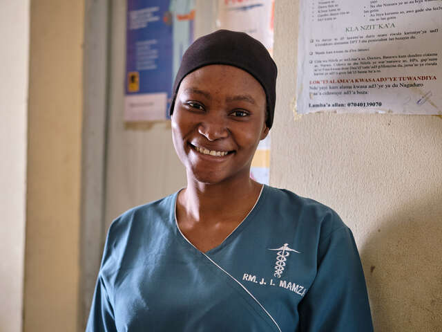 Esther står i sjukhuset och ler.