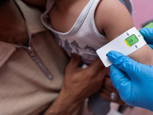 To screen for malnutrition, Wahda measures one-year-old Aws’s arm circumference at the EU-funded clinic.