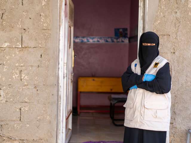 Community health worker and doctor Wahda stands in front of the IRC health centre, ready to examine children who are ill. 