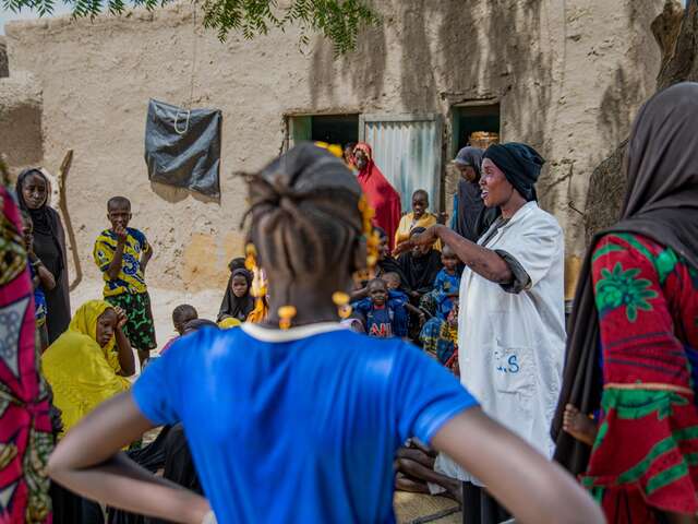 IRC health provider talking to community members 