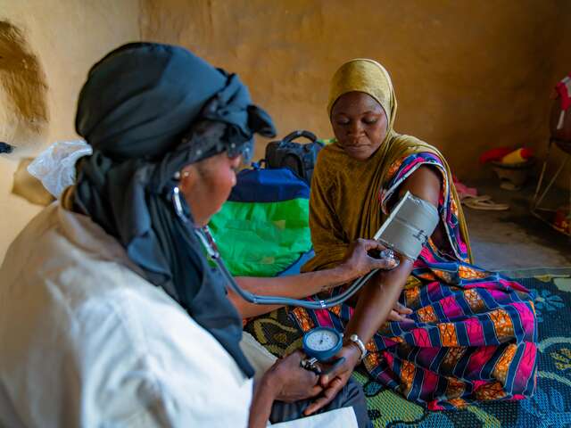 Doctor taking the blood pressure of a woman