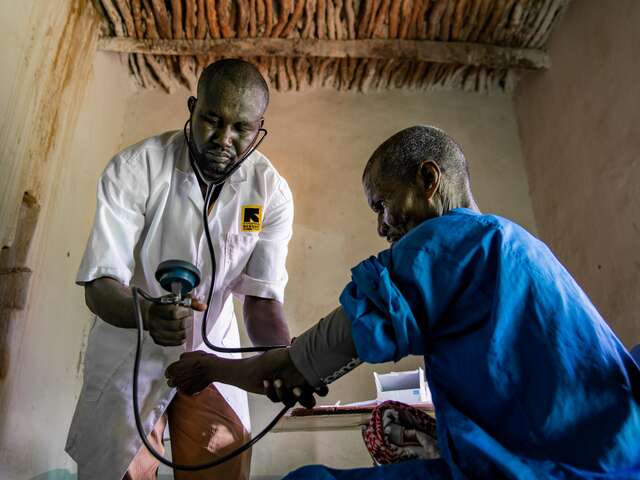 Doctor taking the blood pressure of a man 