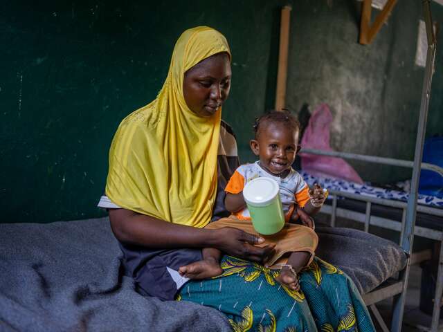 Child smiling on their mother's lap