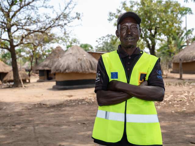 Martin stands in the settlement he patrols through daily home visits to detect and prevent disease outbreaks.