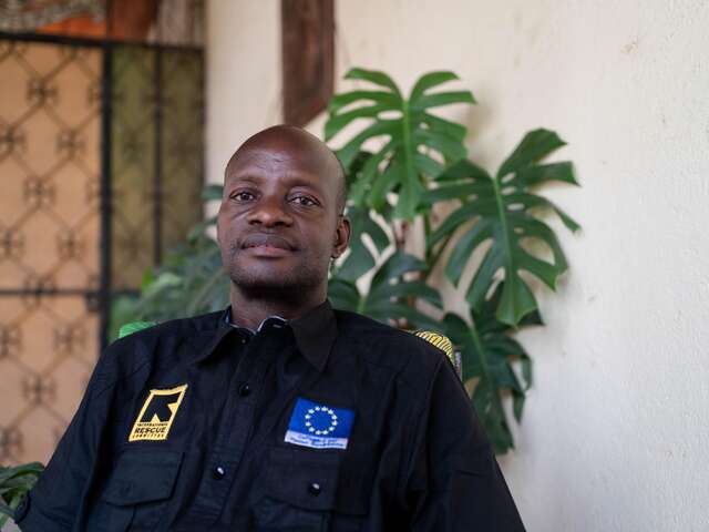 Dr. Cyprien sits in his office, emphasizing the benefits of the IRC project and the importance of continued support. 