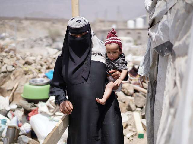 Asriya carrying her child.