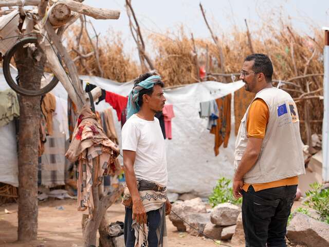 Ahmed speaks with another Ahmed, the IRC senior officer for Emergency Environmental Health, outside his home after receiving cash assistance and supplies.