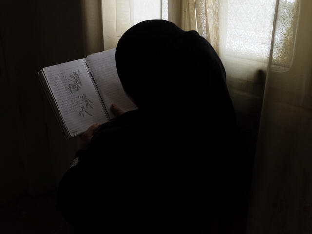 Rawan holds a notebook filled with her writing