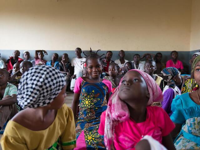 Children waiting in a large group.