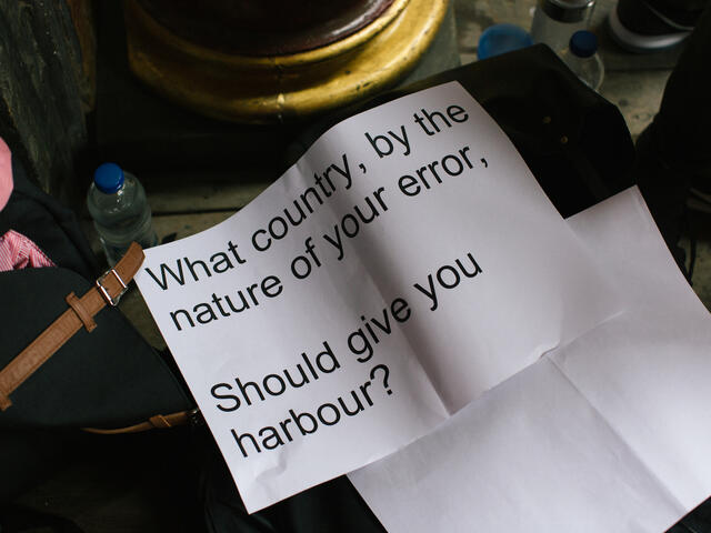 Photograph of the cue card from the film shoot that reads part of the poem: 'What country, by the nature of your error, should give you harbour?'
