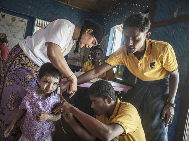 IRC health workers examine a child in a medical clinic in Rakhine State