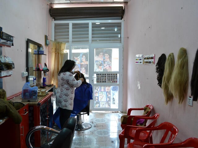Hadeel styles a customer's hair in her salon