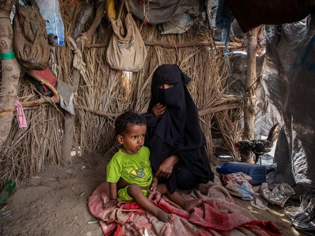 Nadia Mohammed Fadhl with her son Abdullah sit in their temporary shelter in the outskirts of Aden, Yemen.