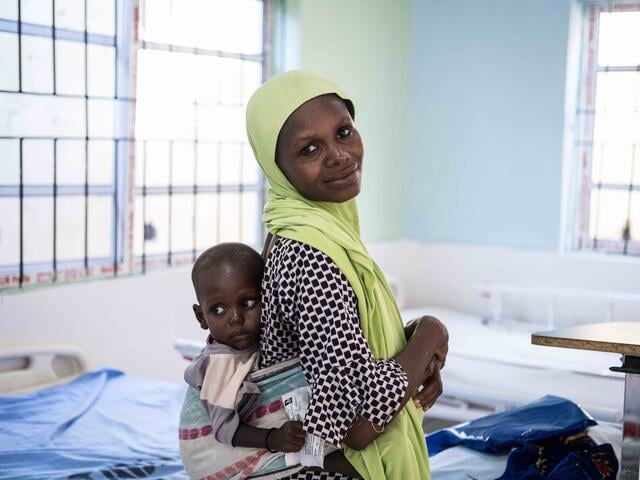 Falmata stands with her son Tujja at the IRC's clinic in northeast Nigeria.
