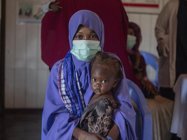 A woman holds her child as she receives treatment for malnutrition in the IRC clinic in Mogadishu.