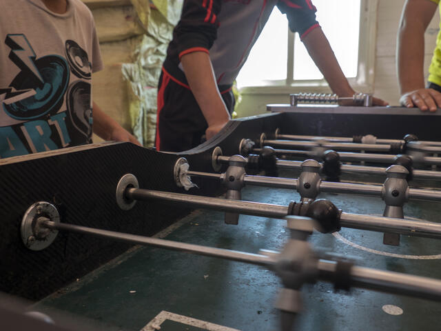 Unaccompanied children living in Azraq refugee camp spend the afternoon playing foosball with friends at a recreation room.