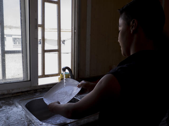 As he waits to be reunited with his family, Samir helps out at the camp reception center by doing small chores such as washing dishes or cleaning the sleeping areas.