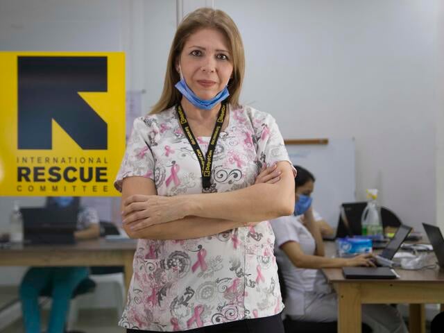 Dr Edna Patricia Gomez stands in front of the IRC medical clinic with her arms folded and mask on her chin.