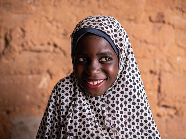 Eight-year-old Fatima smiles whilst looking to the side. 