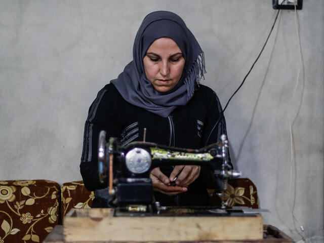 Um Abdo sits infront of her singer sewing machine.