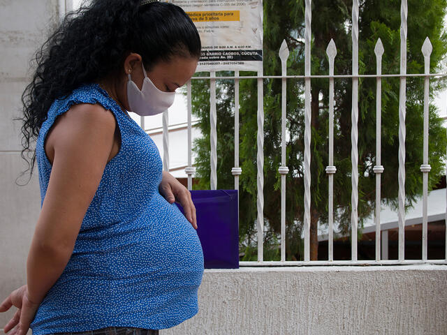A pregnant woman stands outside the IRC's clinic in Colombia.