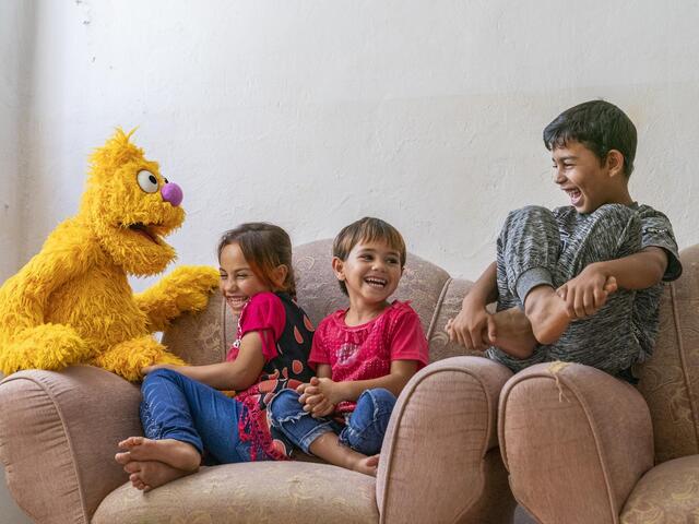 Children sit with new Sesame Street puppet.