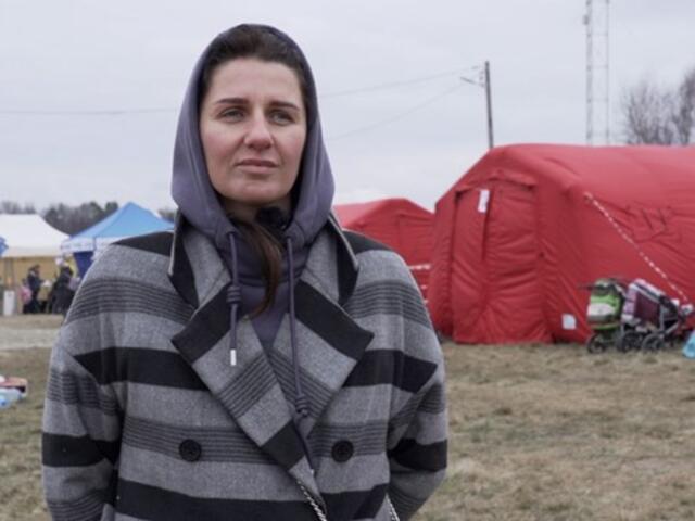 A Ukrainian woman standing in front of a row of tents