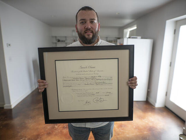 Suamhirs holds a certificate honoring his work on the U.S. Advisory Council on Human Trafficking.