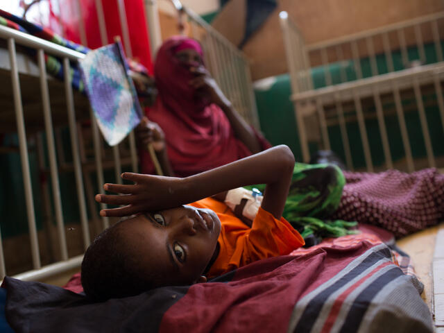 A young boy lies on a cot in the Mogadishu hospital where he is being treated for malnutrition 