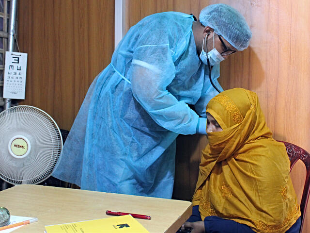 Dr. Sayed Muhaiminur Rahman uses a stethoscope to listen to Sakera's lungs at the IRC primary health care center.