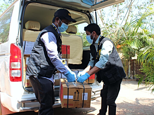 IRC staff unloads coronavirus prevention equipment from a truck