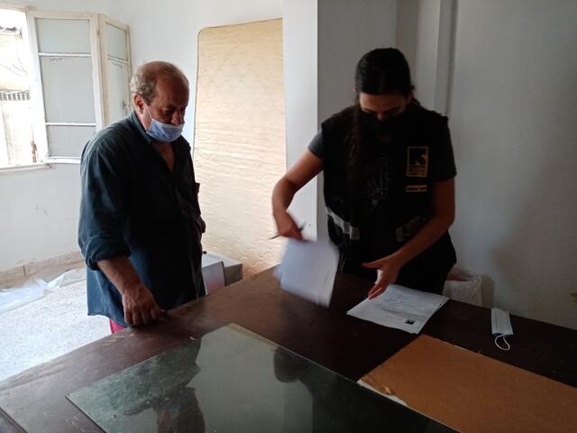 Assad and an IRC staff member review paperwork in his apartment.